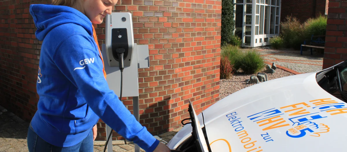 GEW-Mitarbeiterin lädt Elektroauto an moderner Wallbox – Symbol für nachhaltige Elektromobilität und klimafreundlichen Strom von GEW Wilhelmshaven.