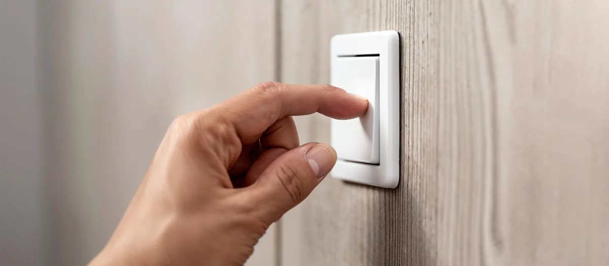 Hand schaltet Licht an – Symbol für verlässliche Grundversorgung mit Havenstrom Basis von GEW Wilhelmshaven.