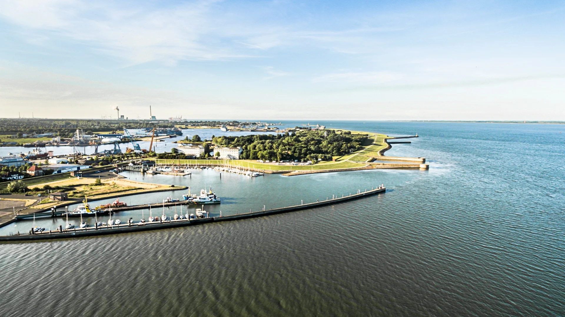 Luftaufnahme von Wilhelmshaven mit Hafen und Nordsee – Symbol für regional erzeugten, nachhaltigen Strom von GEW Wilhelmshaven.