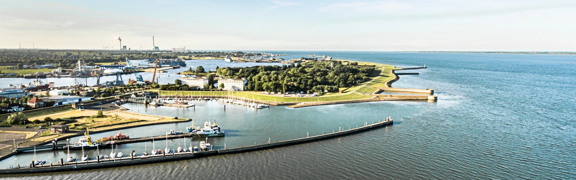 Luftaufnahme von Wilhelmshaven mit Hafen und Nordsee – Symbol für regional erzeugten, nachhaltigen Strom von GEW Wilhelmshaven.