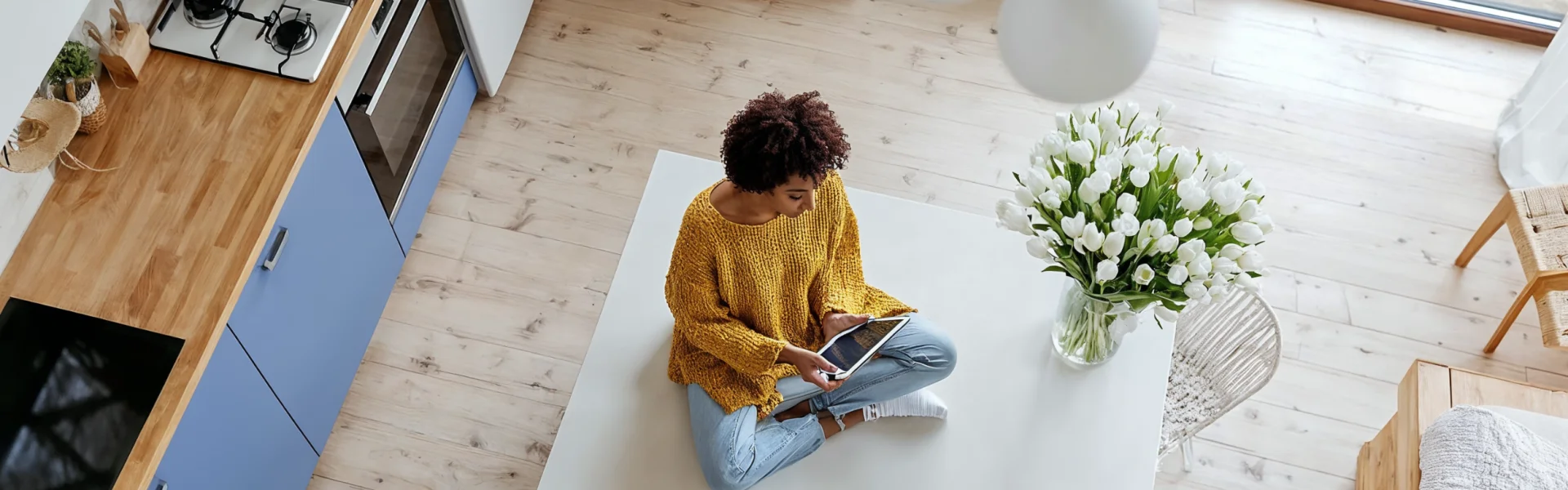 Person sitzt mit Tablet in moderner Küche – Symbol für nachhaltige Energienutzung, digitale Lösungen und Beratung durch GEW Wilhelmshaven.